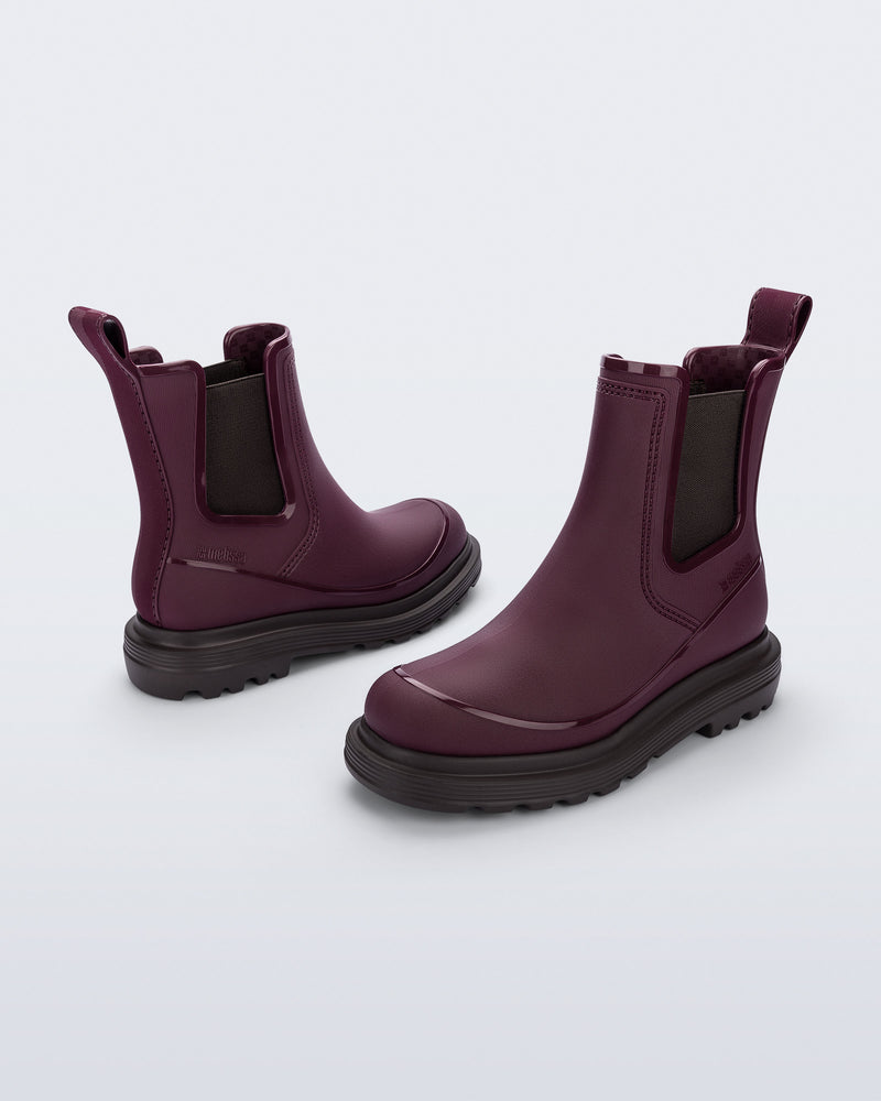 Side angled views of a pair of burgundy Noir Boots with brown soles