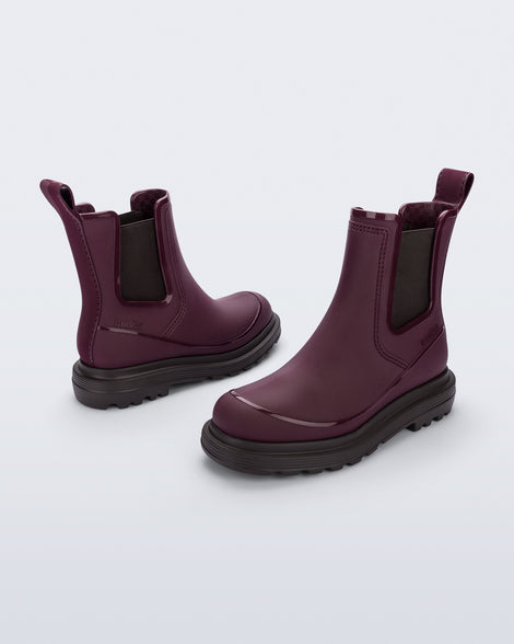 Side angled views of a pair of burgundy Noir Boots with brown soles