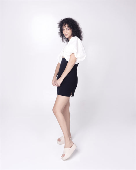 Model in a black skirt and white top wearing a pair of beige Free Platform women's Slides