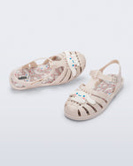 Top and angle view of a pair of beige Possession + Hello Kitty and Friends fisherman sandals with Hello Kitty and friends on the upper