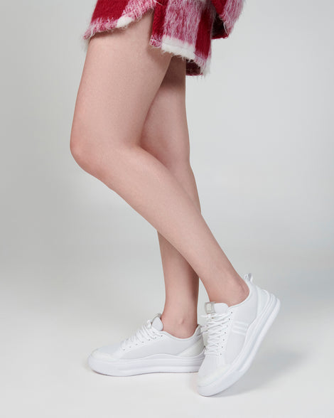 Model's legs wearing a pair of white X Mood sneakers