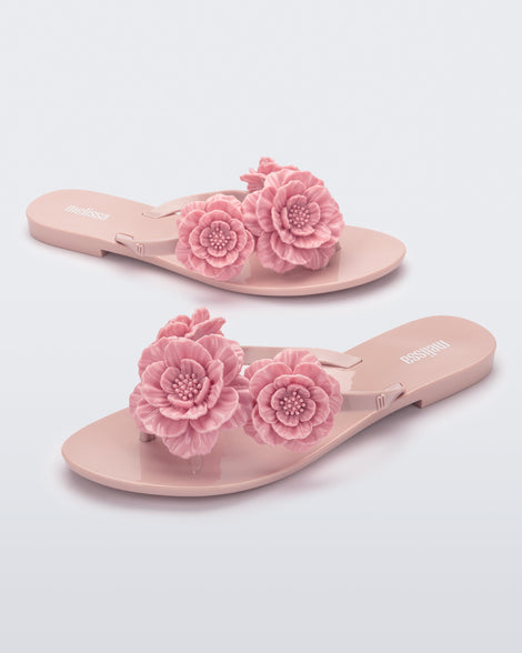 Angled view of a pair of pink Harmonic Springtime women's flip flop with 3 pink flowers.