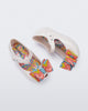 Top and side view of a pair of white with multi-colored patterned bow Ultragirl Wonderland baby flats