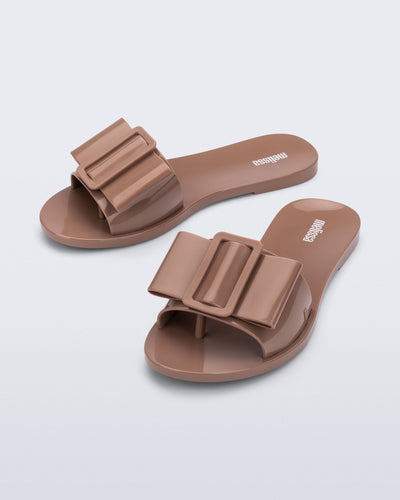 Angled view of a pair of tan Babe slide sandals