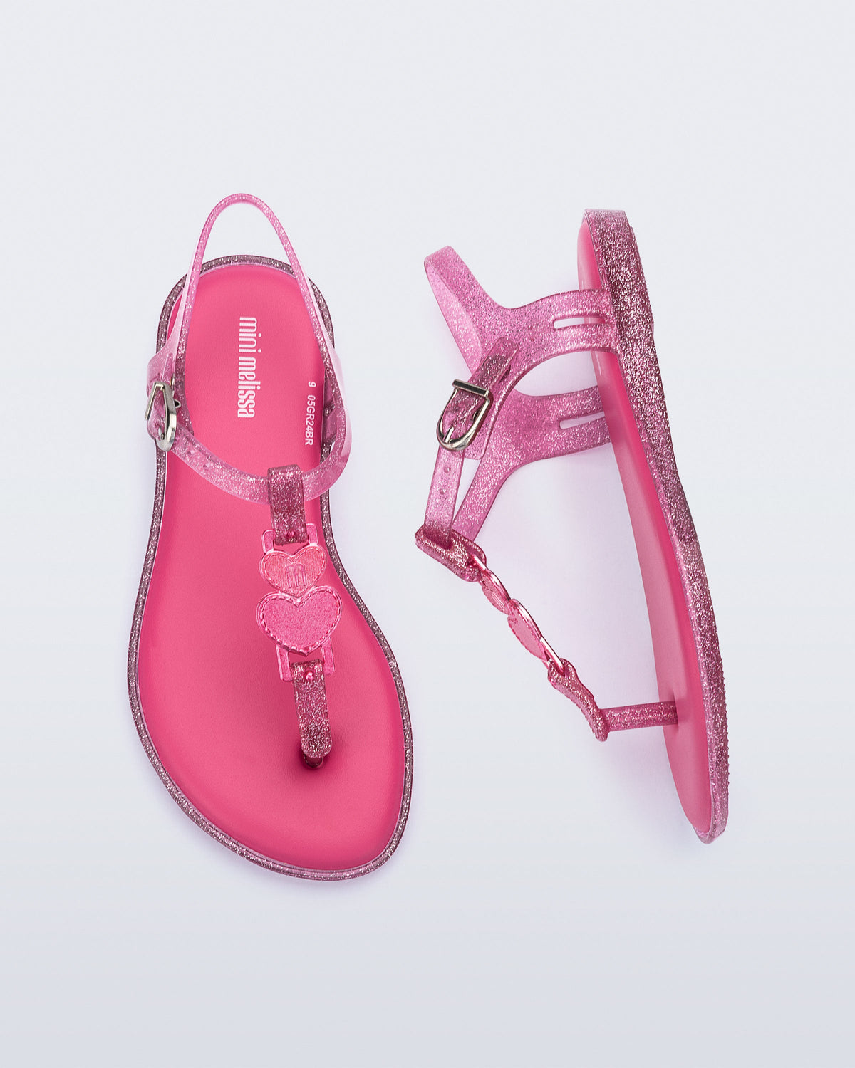 Top and side view of a pair of pink glitter Solar kids sandal with a heart embellishment