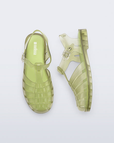 Top and side view of a pair of transparent green Possession fisherman sandals