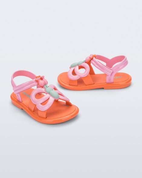 Side and angled view of a pair of pink strap, orange sole Hip Butterfly baby sandals