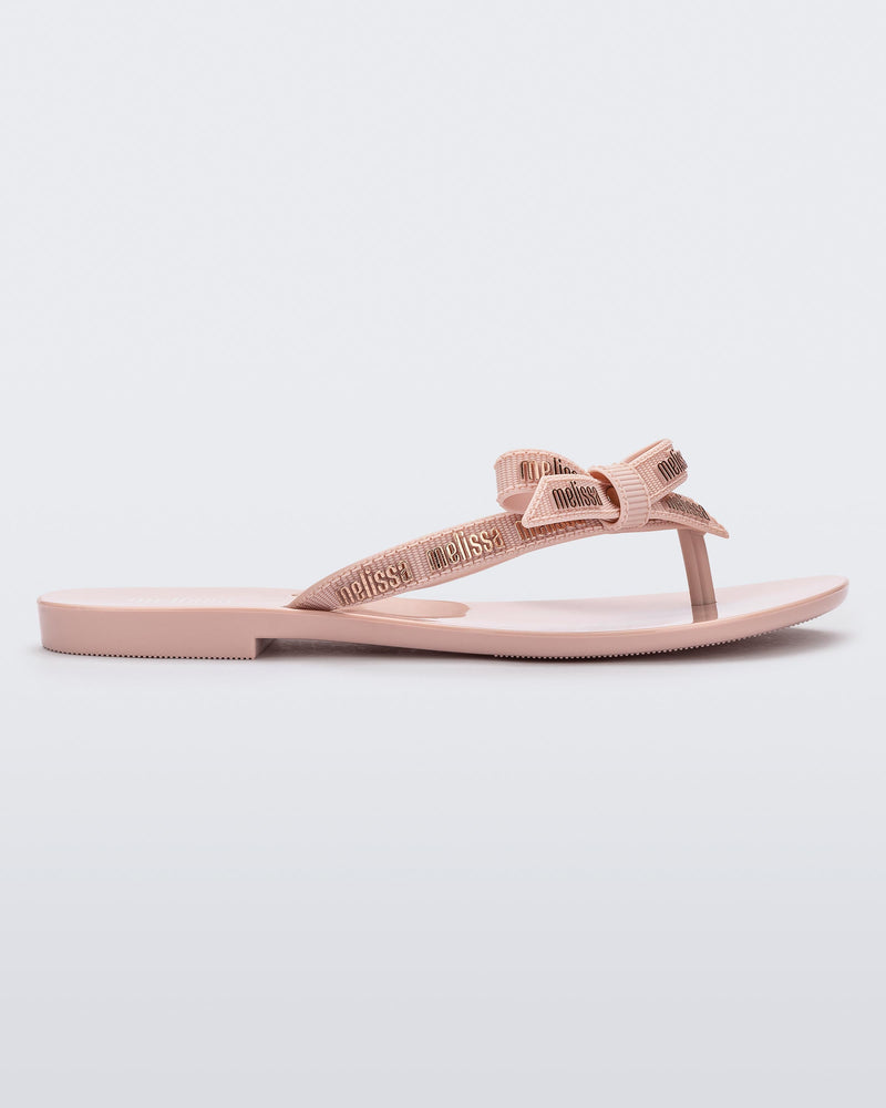 Side view of a light pink Harmonic M Lover adult flip flop with Melissa logo on strap