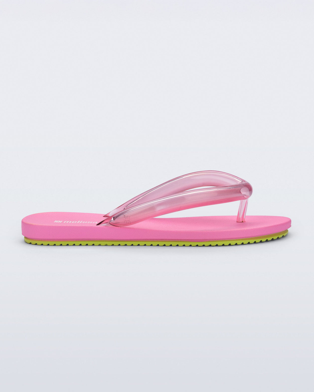 Side view of a pink Flip Flop Airflow sandal with a clear pink strap and green bottom