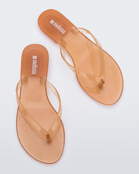 Top view of a pair of clear beige Harmonic Jelly flip flops