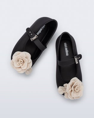 Top view of a pair of black Soft Ballerina baby flats with beige flowers