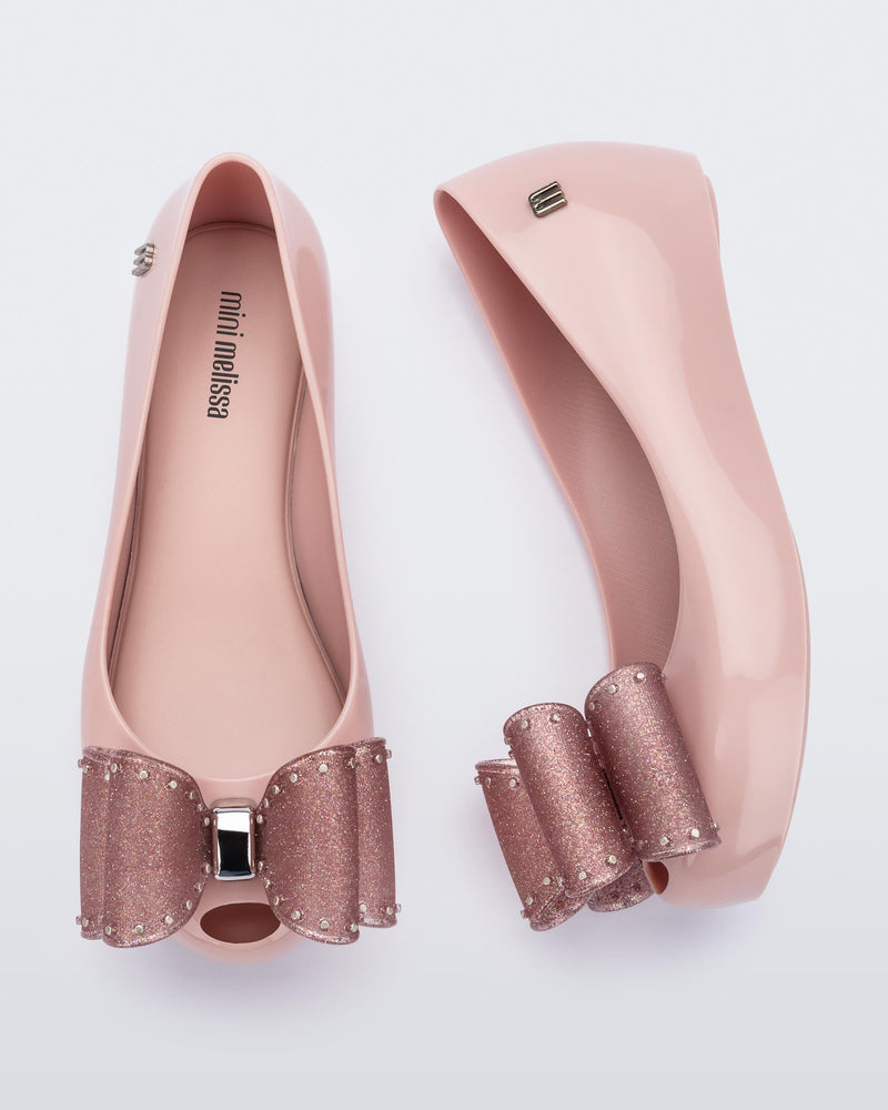 Side and top view of a pair of  light pink Ultragirl Classic Bow kids flats with glitter pink bow on top