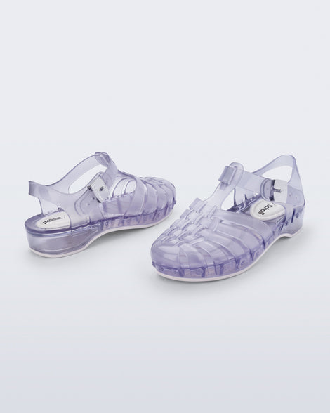 Back and angled view of a pair of clear Possession Pescura + Scholl fisherman sandals with white bottom sole