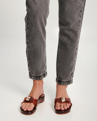 Model's legs wearing a pair of clear brown Pescura Heel + Scholl slides with top buckle