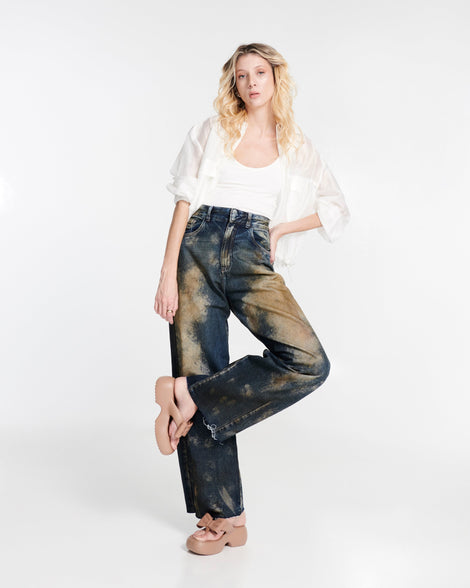 Model in a white shirt and jeans wearing a pair of brown Free Fuzzy Platform flip flops