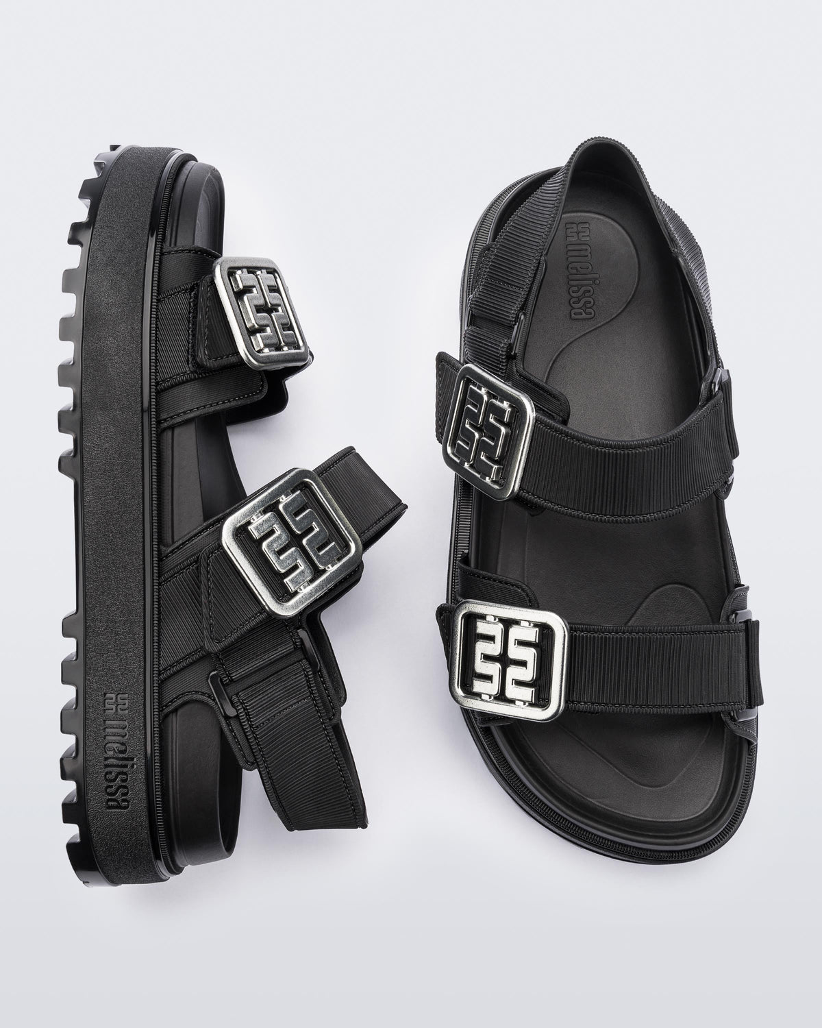 Side and top view of a pair of black Towny sandals with straps and silver buckle