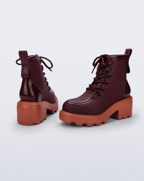Back and angled view of a pair of burgundy Track Boot with small heel and burgundy laces and orange sole