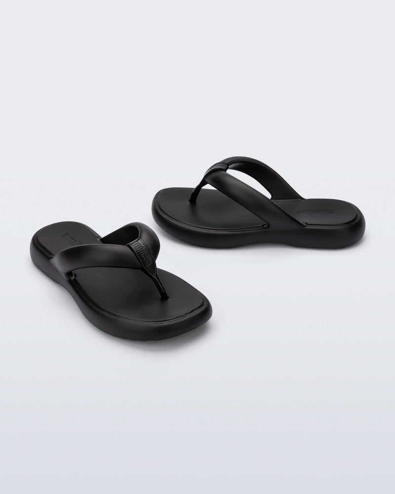 Side and angled view of a pair of black Free Low flip flops