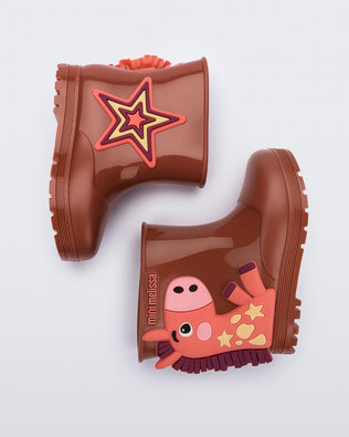 Side view of a pair of brown Welly Wonderland baby boots with orange pony on one shoe and star on the other
