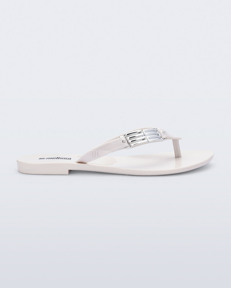 Side view of a white Harmonic M Chic flip flop