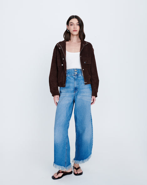 Model in jeans, whit shirt and brown cardigan wearing in a pair of tortoise Wave Flip Flops with small heel and black sole