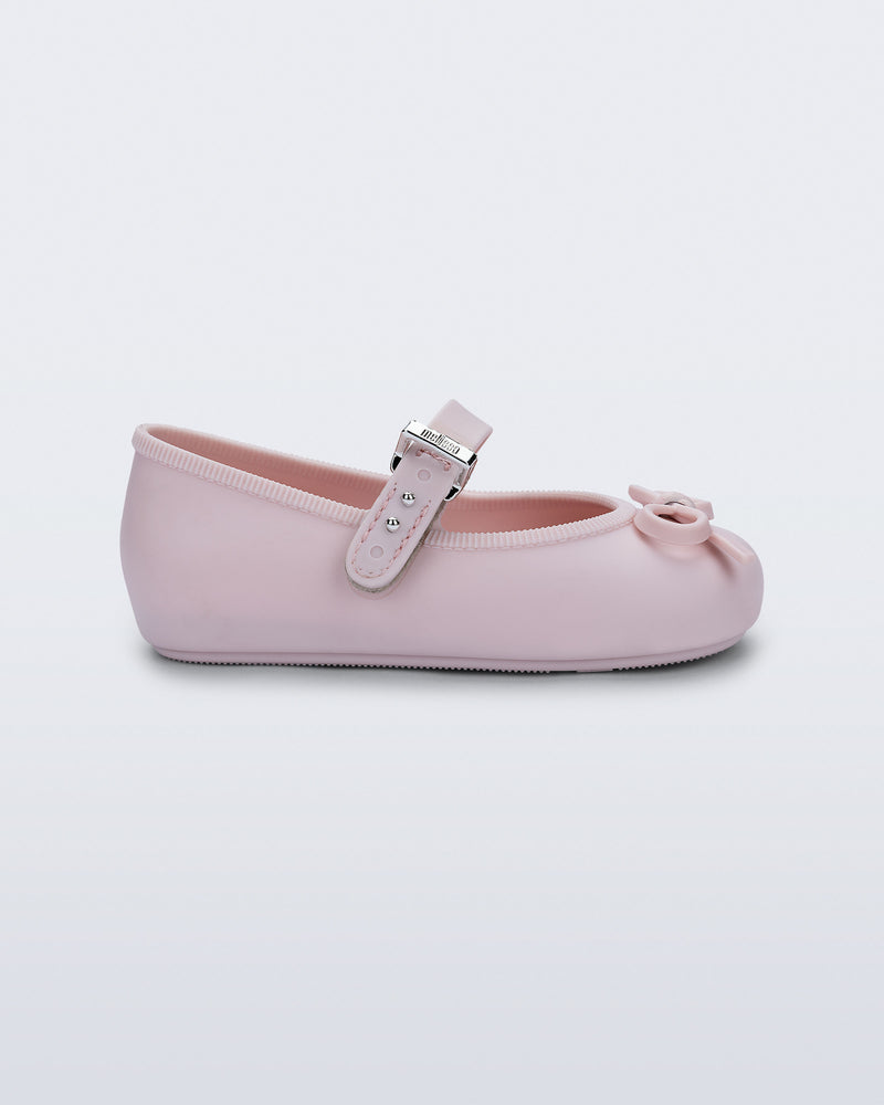 Side view of a pink Soft Ballerina Delicate Bow baby  flat with top strap and bow