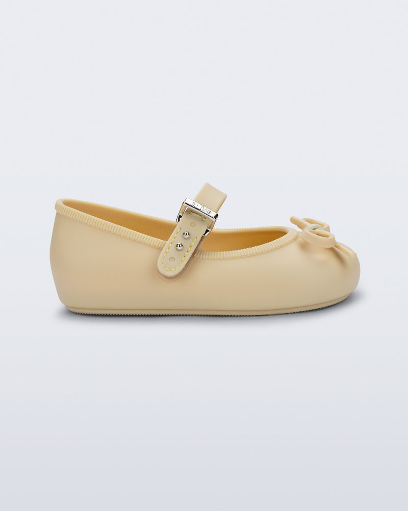 Side view of a yellow Soft Ballerina Delicate Bow baby  flat with top strap and bow
