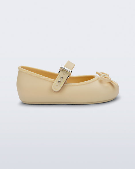 Side view of a yellow Soft Ballerina Delicate Bow baby  flat with top strap and bow