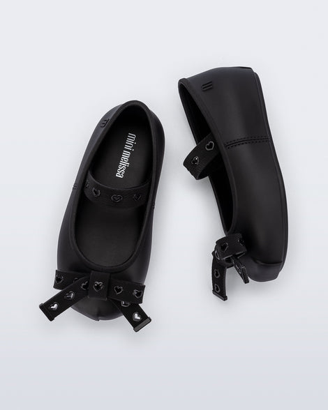 Top and side view of a pair of black Sophie Crush baby ballerina flats with bow