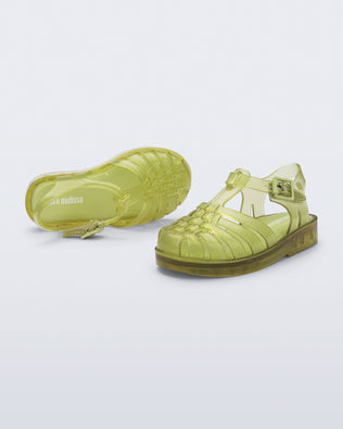 Top and angled view of a pair of transparent green Possession fisherman baby sandals