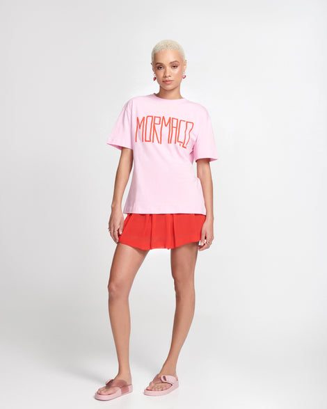 Model in a pink outfit wearing a pair of pink Cozy Thong flip flops