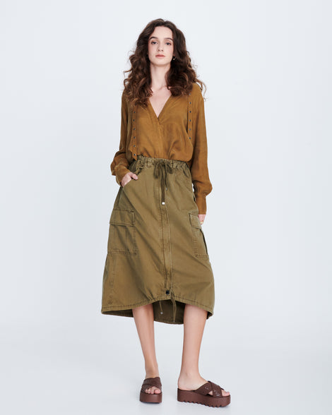 Model in a long brown skirt and brown top wearing a pair of black M Lover Cross Strap platform slides