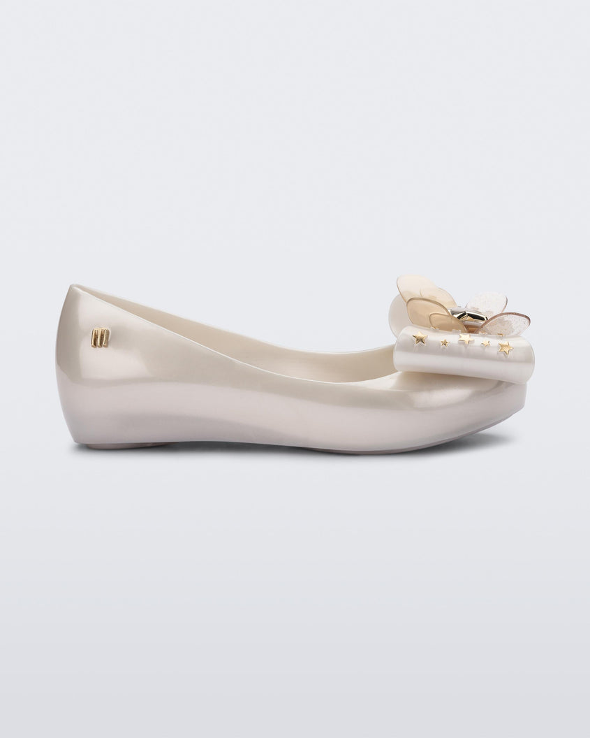 Side view of a Mini Melissa Ultragirl peeptoe ballet flat in white with star printed butterfly bow applique. 