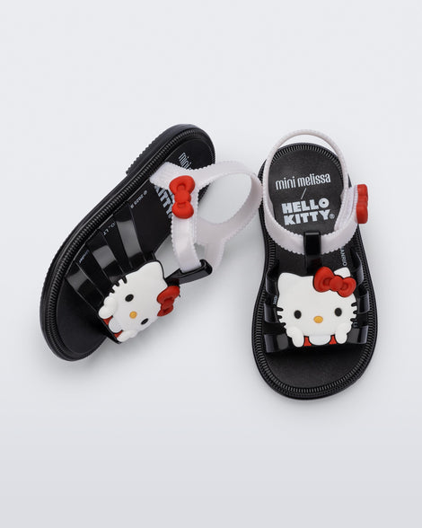 Side and top view of a pair of black Hip + Hello Kitty and Friends sandals with white ankle straps and Hello Kitty on upper
