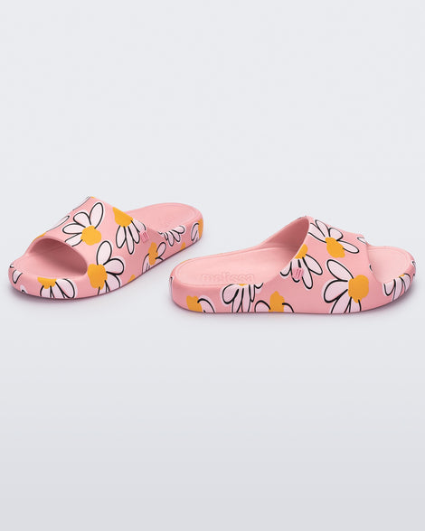 Angled view of a pair of pink Free Print Slides with daisy print flowers