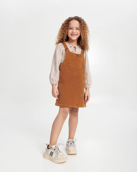 Child model in brown jumper wearing a pair of off white X Beat baby sneakers with black trim