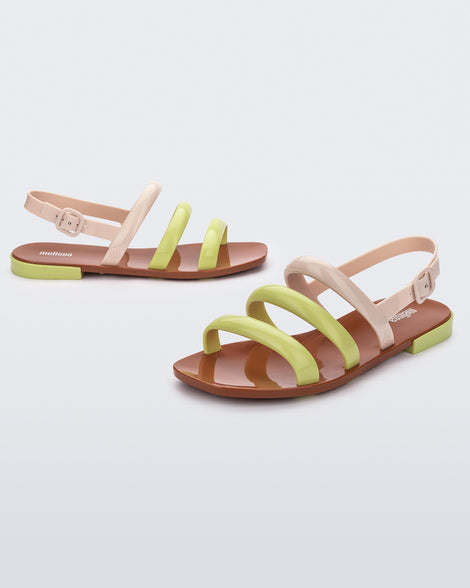 Angled view of a pair of beige and yellow Essential Wave women's sandal with adjustable buckle.