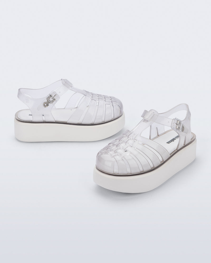 Back and angled view of a pair of clear Possession Platform kids fisherman sandals with white soles