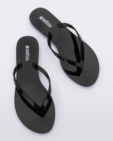 Top view of a pair of clear black Harmonic Jelly flip flops