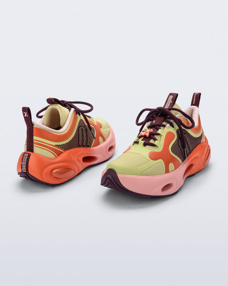 Back and angled view of a pair of orange/green/pink X Loop sneakers
