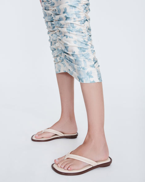 Model's legs in a pair of beige Wave Flip Flops with small heel and brown sole