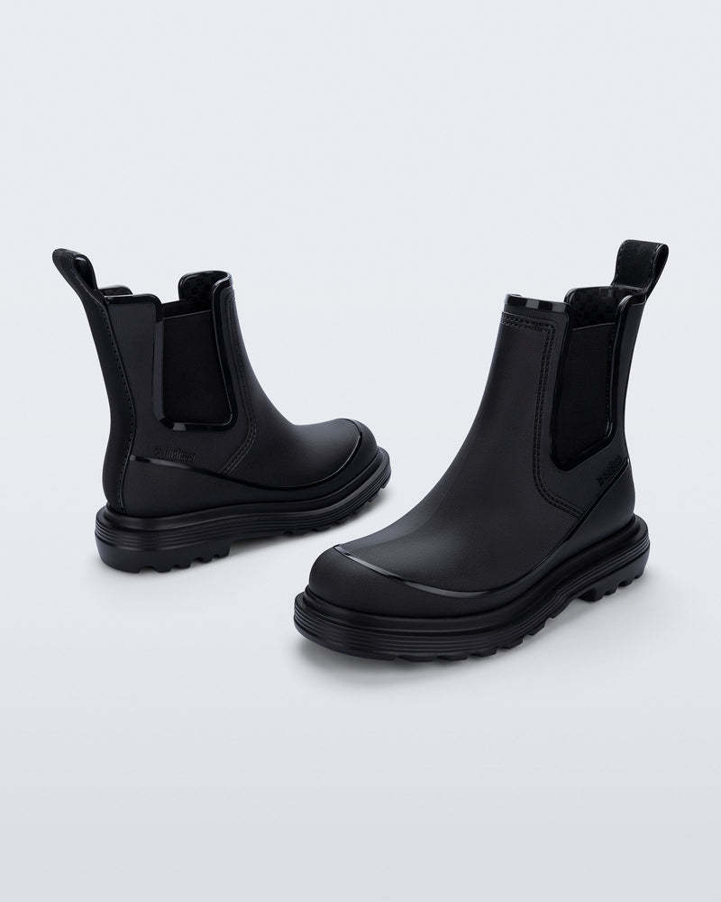 Side angled views of a pair of black Noir Boots with black soles