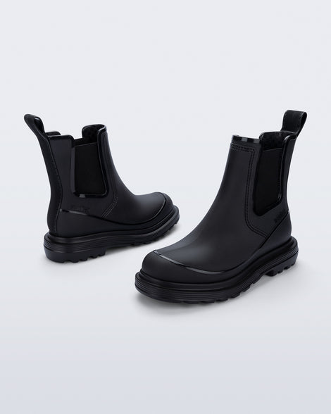 Side angled views of a pair of black Noir Boots with black soles