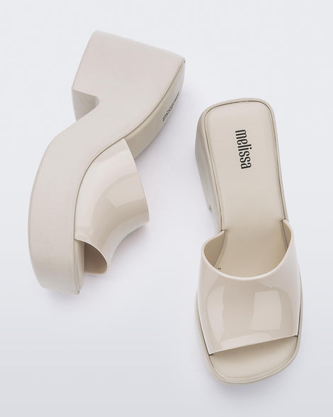 Top and side view of a pair of beige Posh platform heels