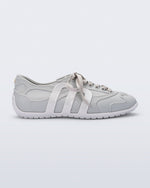 Side view of a grey Motion sneaker with white colored sole and M monogram