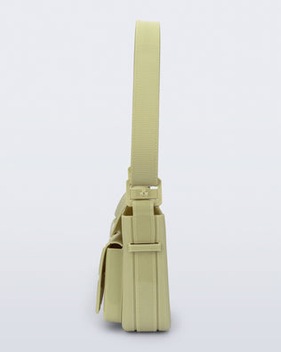 Side view of a pastel green Cargo bag with two small pockets on the front and an adjustable strap