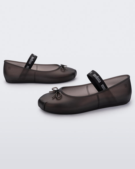 Angled view of a pair of Melissa Sophie ballet flats in black with M-logo strap and bow applique