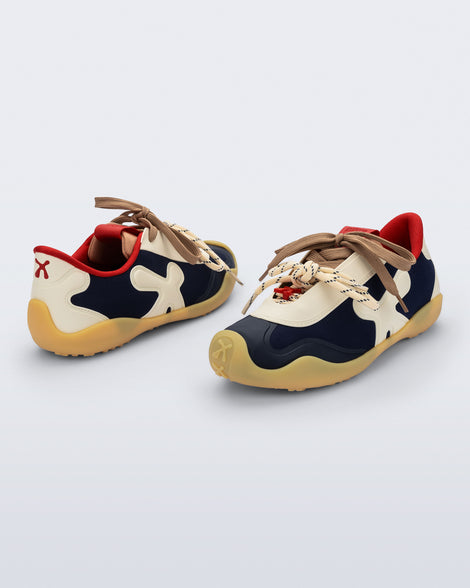 Back and angled view of a pair of black and beige X Bend sneakers with yellow sole