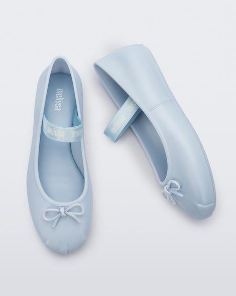 Top and side view of a pair of Melissa Sophie ballet flats in blue with M-logo strap and bow applique