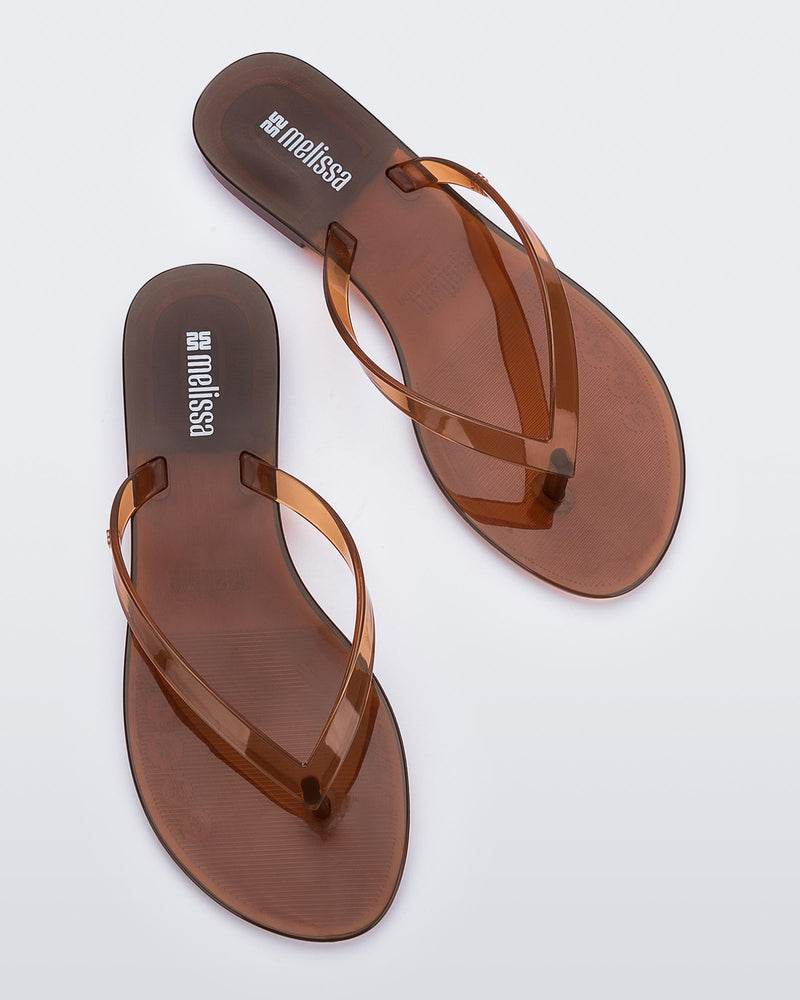 Top view of a pair of clear brown Harmonic Jelly flip flops